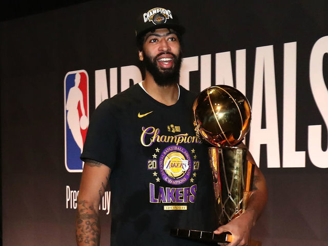 Anthony Davis holding the Larry O'Brien Trophy